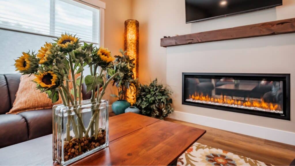 A vacation rental property manager arranges the home, here the living room has sunflowers and an electronic fireplace 